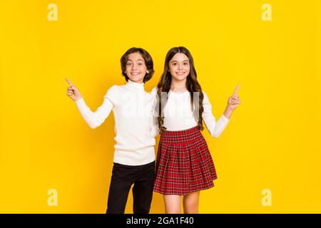 Foto-Porträt von Kindern zeigen Finger leeren Raum isoliert auf lebendigen gelben Hintergrund Stockfoto