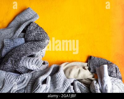 Warme Strickpullover und Pullover auf hellgelbem Hintergrund. Stockfoto
