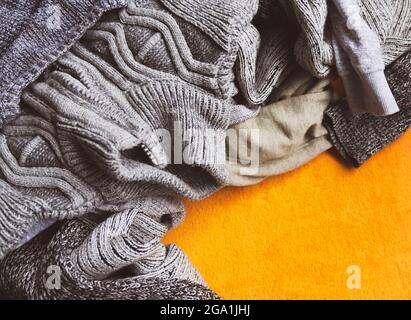 Warme Strickpullover und Pullover auf hellgelbem Hintergrund. Stockfoto