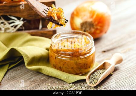 Zwiebelmarmelade in einem Glas auf einem Holztisch. Zwiebel Confiture hausgemachte Konservierung Stockfoto