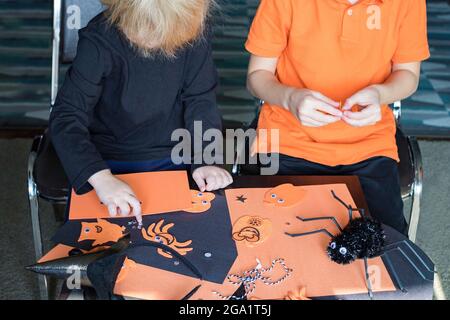 Halloween Kinder Handwerk Vorbereitungen. Kleine Kinder basteln zu Hause. Feiertagskonzept mit DIY-Dekorationen Stockfoto