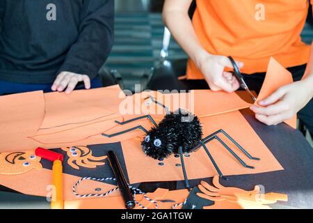 Halloween Kinder Handwerk Vorbereitungen. Kleine Kinder basteln zu Hause, im Kindergarten oder in der Schule. Halloween Kinder Party Konzept. Stockfoto