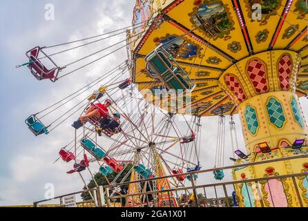 SKEGNESS, LINCOLNSHIRE, GROSSBRITANNIEN. Juli 2021. Großbritannien Wetter, Wirtschaft, Unternehmen. Während die Aufhebung der kovidierten Sicherheitsmaßnahmen anhält, erweisen sich die Küstenstädte Großbritanniens als ein sehr beliebtes Reiseziel für die Sommerferien, zusammen mit dem kürzlich guten heißen, sonnigen Wetter strömen Massen an die Küste. Das Bild zeigt Jude und Oscar Wilkinson bei einer mitreissenden Fahrt auf dem Flying Chairs Fairground bei Skegness's Strandunterhaltung. Quelle: phil wilkinson/Alamy Live News Stockfoto