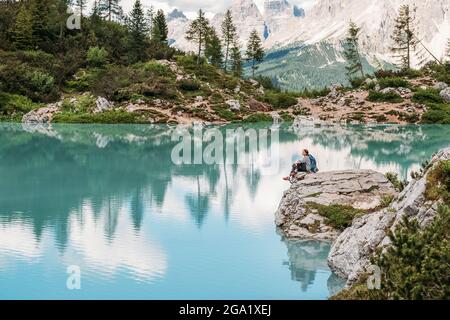 Backpacker-Frau mit Rucksack, die den türkisfarbenen Lago di Sorapiss 1.925m Höhe (Bergsee) Blick genießt, während er Bergwanderung im Dolomite Mounta hat Stockfoto