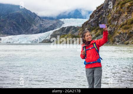 Touristenfrau, die Selfie-Fotos am Mendenhall-Gletscher in Juneau, Alaska, macht. Berühmtes Tourismusziel auf Alaska-Kreuzfahrt, USA-Reise Stockfoto