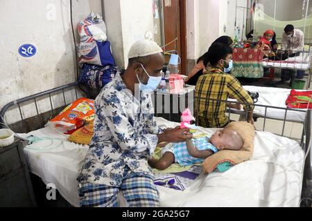 Eine Person spielt mit ihrer Tochter, während sie im Kinderkrankenhaus aufwartet, weil sie sich am 28. Juli 2021 in Dhaka, Bangladesch, von einem neuen Ausbruch des Dengue-Virus infiziert hatte. Foto von Habibur Rahman/Eyepix/ABACAPRESS.COM Stockfoto