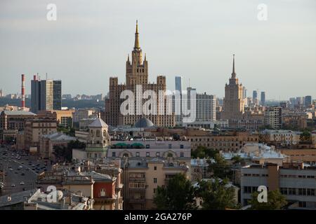 Zwei stalinistische Wolkenkratzer und das Weiße Haus von Russland. Moskau. Panoramablick auf die Stadt am blauen Himmel mit leichtem Dunst oder Smog. Stockfoto