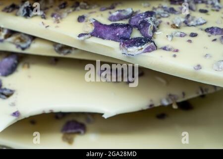 Beste weiße Schokoladenfliese mit Pistazie und Violett. Weißer Hintergrund, Nahaufnahme. Hochwertige Fotos Stockfoto