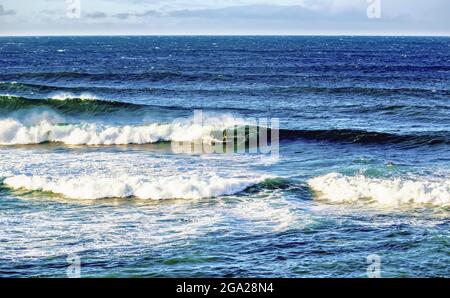 Im Ho'okipa Bach Park in der Nähe von Paia mit blauer Meereslandschaft und wolkendem Himmel reitet ein einmüsigem Surfer auf den Wellen; Maui, Hawaii, USA Stockfoto