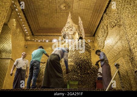 Pilger legen Blattgold auf das Maha Muni Buddha Bild, in der Großen Salbei Pagode, Mandalays wichtigster religiöser Struktur, Myanmar-Burma Stockfoto