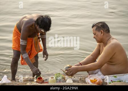Priester, der eine hinduistische Puja am Ufer des Ganges durchführt; Varanasi, Uttar Pradesh, Indien Stockfoto