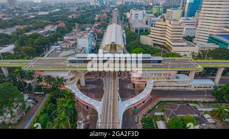 Luftaufnahme der artikulierten Stadtbusse, die am Busbahnhof in der Nähe des Hauptbahnhofs MRT-Linie bei Kebayoran Baru ankommen und abfahren. Jakarta, Indonesien, Ju Stockfoto
