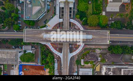 Luftaufnahme der artikulierten Stadtbusse, die am Busbahnhof in der Nähe des Hauptbahnhofs MRT-Linie bei Kebayoran Baru ankommen und abfahren. Jakarta, Indonesien, Ju Stockfoto
