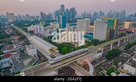 Luftaufnahme der artikulierten Stadtbusse, die am Busbahnhof in der Nähe des Hauptbahnhofs MRT-Linie bei Kebayoran Baru ankommen und abfahren. Jakarta, Indonesien, Ju Stockfoto