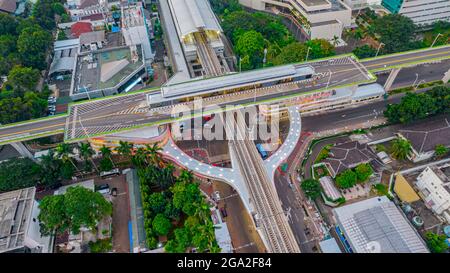Luftaufnahme der artikulierten Stadtbusse, die am Busbahnhof in der Nähe des Hauptbahnhofs MRT-Linie bei Kebayoran Baru ankommen und abfahren. Jakarta, Indonesien, Ju Stockfoto