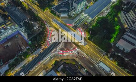 Luftaufnahme der artikulierten Stadtbusse, die am Busbahnhof in der Nähe des Hauptbahnhofs MRT-Linie bei Kebayoran Baru ankommen und abfahren. Jakarta, Indonesien, Ju Stockfoto