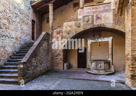 Mittelalterlicher Brunnen im Innenhof des Palazzo del Popolo; San Gimignano, Provinz Siena, Toskana, Italien Stockfoto