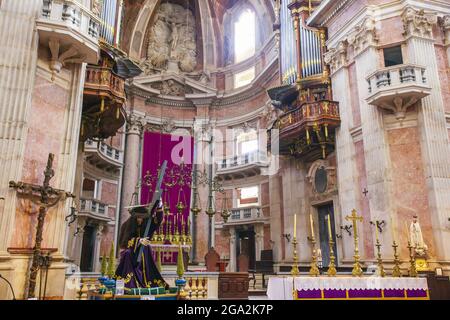 Der reich verzierte Hauptaltar der Basilika des Mafra-Palastes und des Klosters mit seinem historischen Satz von Pfeifenorgeln oben und einer Skulptur, die Jesus ... Stockfoto