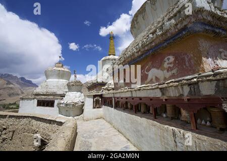 Nahaufnahme eines Betonweges durch die weißgetünchten buddhistischen Stupas (in der tibetischen Kultur als Chöre bekannt) und Gebetsräder an den Lamayuru Monas... Stockfoto