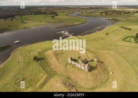 Luftaufnahme der Ruinen von Clonmacnoise Castle auf einer grasbewachsenen motte mit Kühen, die auf den umliegenden Feldern grasen, mit einem... Stockfoto