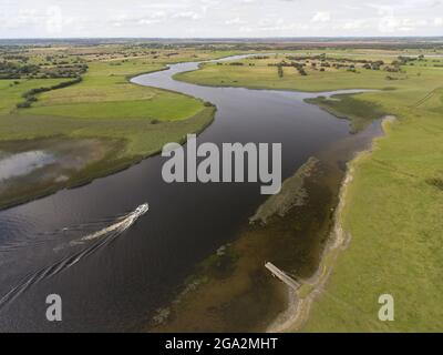 Luftaufnahme eines Bootes, das den Fluss Shannon entlang der Ufer der Clonmacnoise Ruinen erkundet; Grafschaft Offaly, Irland Stockfoto