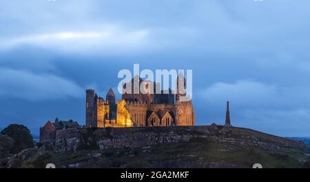 Der alte Rock of Cashel, der in der Abenddämmerung beleuchtet wird; Cashel, County Tipperary, Irland Stockfoto