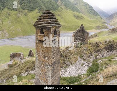 Die Ruinen von verlassenen Steinwachtürmen, einer mit dem traditionellen Stufenpyramidendach, im Bergdorf Girevi in der Tusheti Natio... Stockfoto