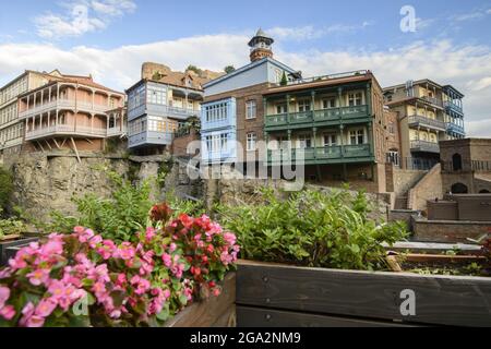 Von Balkonen mit Blumenkästen mit Blick über den Tsavkisi-Tskali-Fluss bis zu den alten Backsteingebäuden mit Holzbalkonen, die auf den Klippen in L... Stockfoto