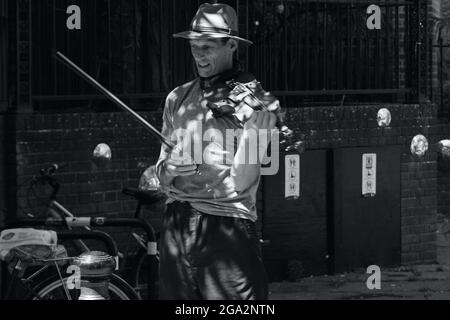 Hastings, East Sussex, England Großbritannien 4. Juli 2021: Ein Straßenmusiker spielt in den Straßen der Altstadt von Hastings für Touristen, die in den Geschäften herumlaufen Stockfoto