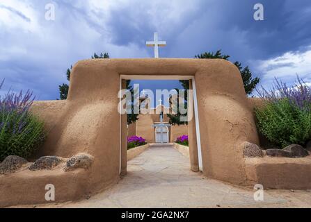 Blick durch die adobe-Tore zum Eingang und zur Fassade der historischen Kirche San Francisco de Asis auf dem hauptplatz von Ranchos de Taos Stockfoto