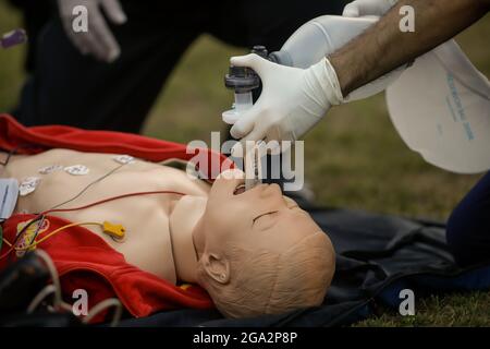 Bukarest, Rumänien - 28. Juli 2021: Sanitäter führen während einer öffentlichen Demonstration zur Rettung eines Opfers eine HLW an einem Plastikdummy durch. Stockfoto