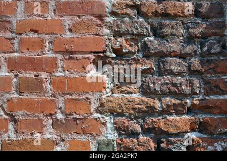 Teil der Wand aus altem rotem Backstein. Hintergrund. Stockfoto