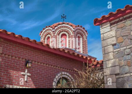 Nahaufnahme der prunkvollen Kuppel und der Ziegeldach mit Backstein- und Steinfassade der Nikolaikapelle im griechisch-orthodoxen Kloster St. Anthony Stockfoto