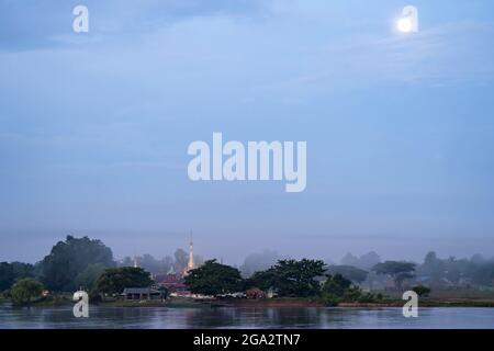 Vollmond über einer Dorffeldstupa am Dschungel am Ayeyarwady (Irrawaddy)-Fluss; ländlicher Dschungel, Kachin, Myanmar (Burma) Stockfoto