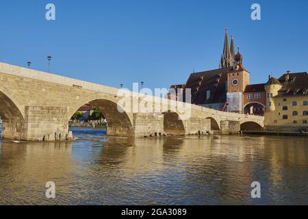 Alte Steinbrücke aus dem 12. Jahrhundert und der gotische Petersdom (Regensburger Dom) an der Donau in der Altstadt von Regensburg mit einem... Stockfoto