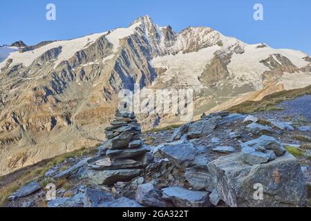 Cairn steht mit dem Großglockner im Hintergrund neben dem Gamsgrubenweg, Franz-Joseph-hohe an einem frühen Morgen; Karnten, Österreich Stockfoto