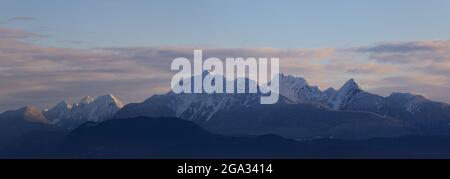 Golden Ears Berggipfel mit einem Schein des Sonnenuntergangs aus Surrey, BC; British Columbia, Kanada Stockfoto