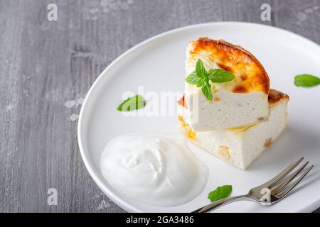 Kasserolle mit Rosinen und Grieß auf grauem Holzgrund. Kasserolle mit Quark. Stockfoto