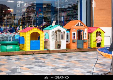 Kinder spielen Spielzeughaus aus Kunststoff auf dem Display vor Smyths Spielzeug-Shop Stockfoto