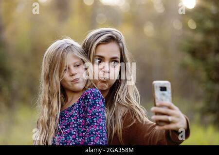 Eine Mutter, die mit ihrer Tochter im Freien viel Zeit verbringt und ein Selbstporträt in einem Stadtpark macht; Edmonton, Alberta, Kanada Stockfoto