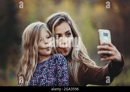 Eine Mutter, die mit ihrer Tochter im Freien viel Zeit verbringt und ein Selbstporträt in einem Stadtpark macht; Edmonton, Alberta, Kanada Stockfoto