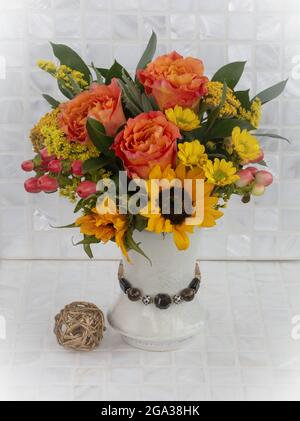 Ein schöner und farbenfroher Blumenstrauß mit frischen Schnittblumen auf einer weißen Fliesenoberfläche; Studio Stockfoto