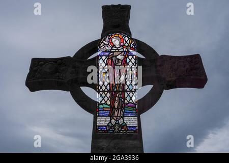Doppelbelichtung von Glasmalerei und St. Martins Kreuz in der Benediktinerabtei auf Iona, Schottland; Iona, Isle of Iona, Schottland Stockfoto
