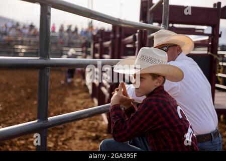 3. Juli 2021; Bloomington, Indiana: Ein Junge beobachtet, wie ein Ansager vor dem 3 Bar J Rodeo am 2. Juli auf der Monroe County Fair Einführungen gibt. Stockfoto