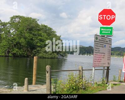 Blick auf Lake Windermere an der Autofähre von Far Sawrey mit Hinweisen auf den Gebührenplan für Fußgänger und Fahrzeuge. Stockfoto