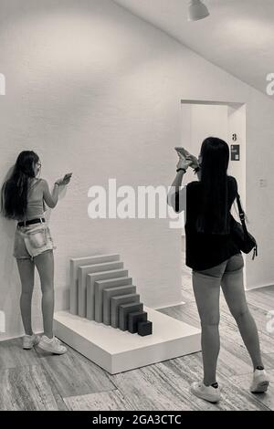 Zwei junge Mädchen, die im spanischen Museum für abstrakte Kunst der Stiftung Juan March in Cuenca mit einem Handy ein Foto einer Skulptur machen, Spanien. Stockfoto
