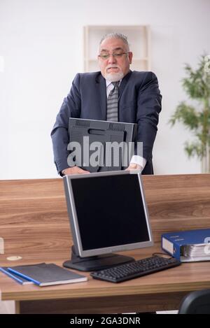 Gealterter Geschäftsmann, der am Arbeitsplatz sitzt Stockfoto