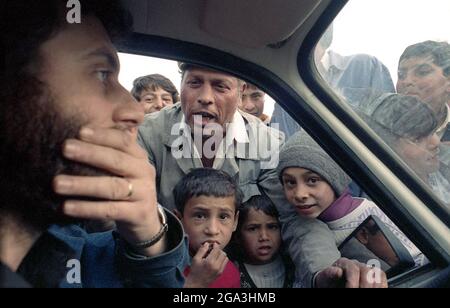 Der rumänische Regisseur Dominic Dembinski, 1990. Eine Gruppe Zigeuner (Rroma/Romani) bettelt am Fenster seines Fahrzeugs. Stockfoto