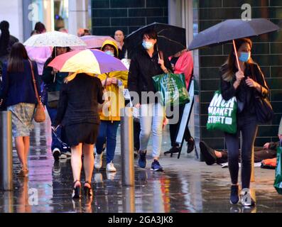 Gewitter und heftiger Regen im Stadtzentrum von Manchester, Großbritannien. Die Menschen versuchen, den Regen im Stadtzentrum am 28. Juli 2021 zu vermeiden. Stockfoto