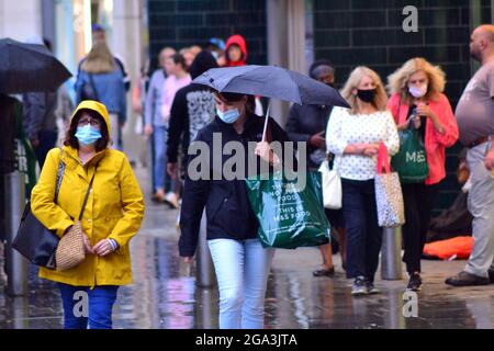 Gewitter und heftiger Regen im Stadtzentrum von Manchester, Großbritannien. Die Menschen versuchen, den Regen im Stadtzentrum am 28. Juli 2021 zu vermeiden. Stockfoto